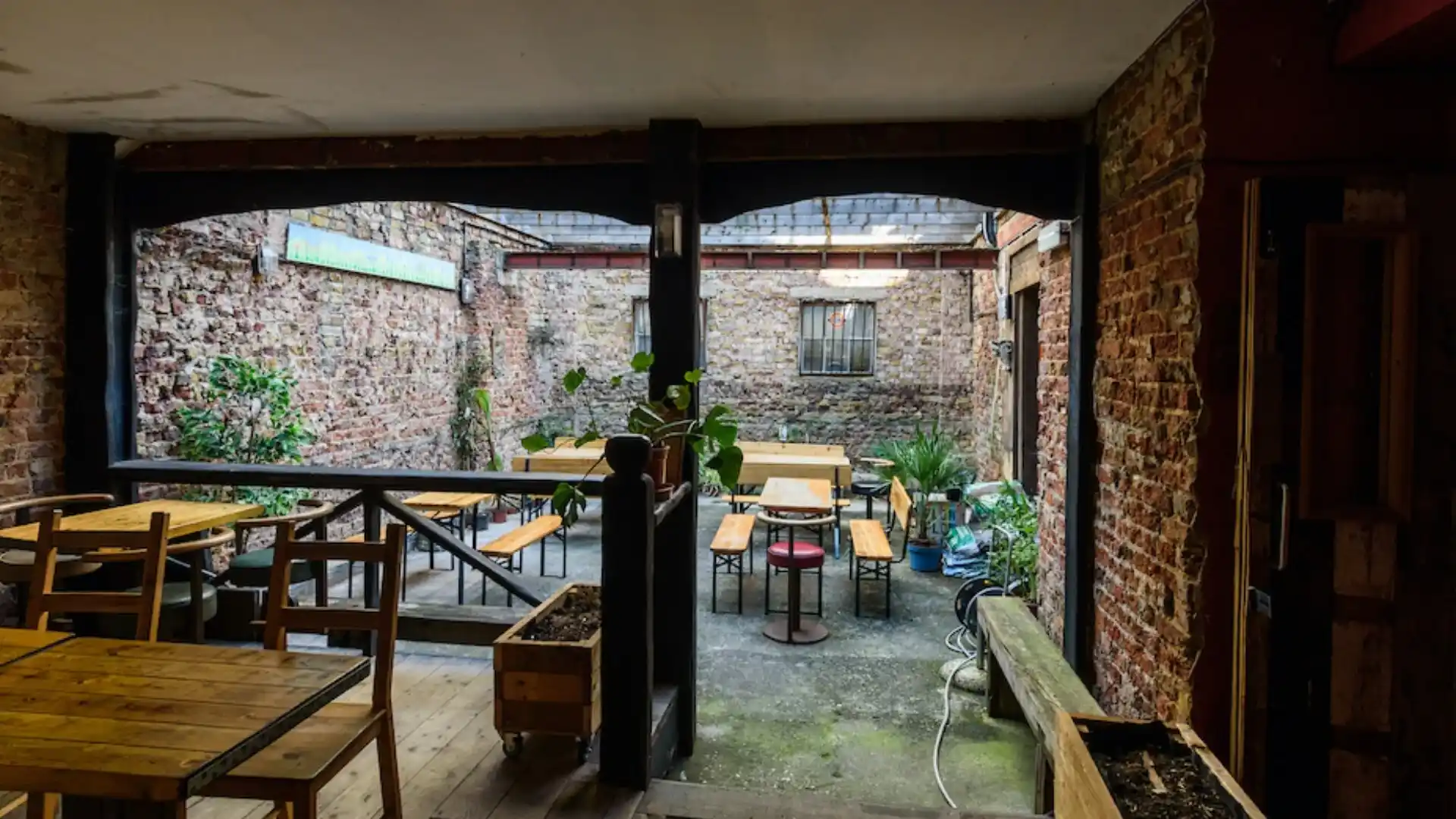 Outdoor seating with plenty of foliage and fold out tables and benches