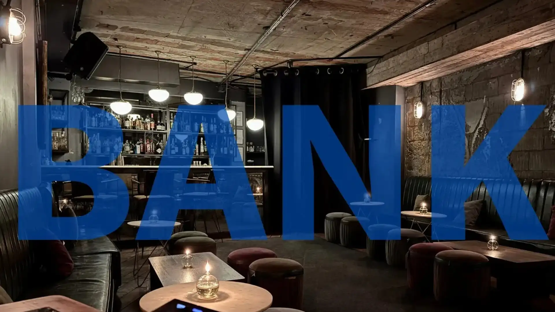 Main bar and lounge area of Bank Speakeasy, candle lit and intimate