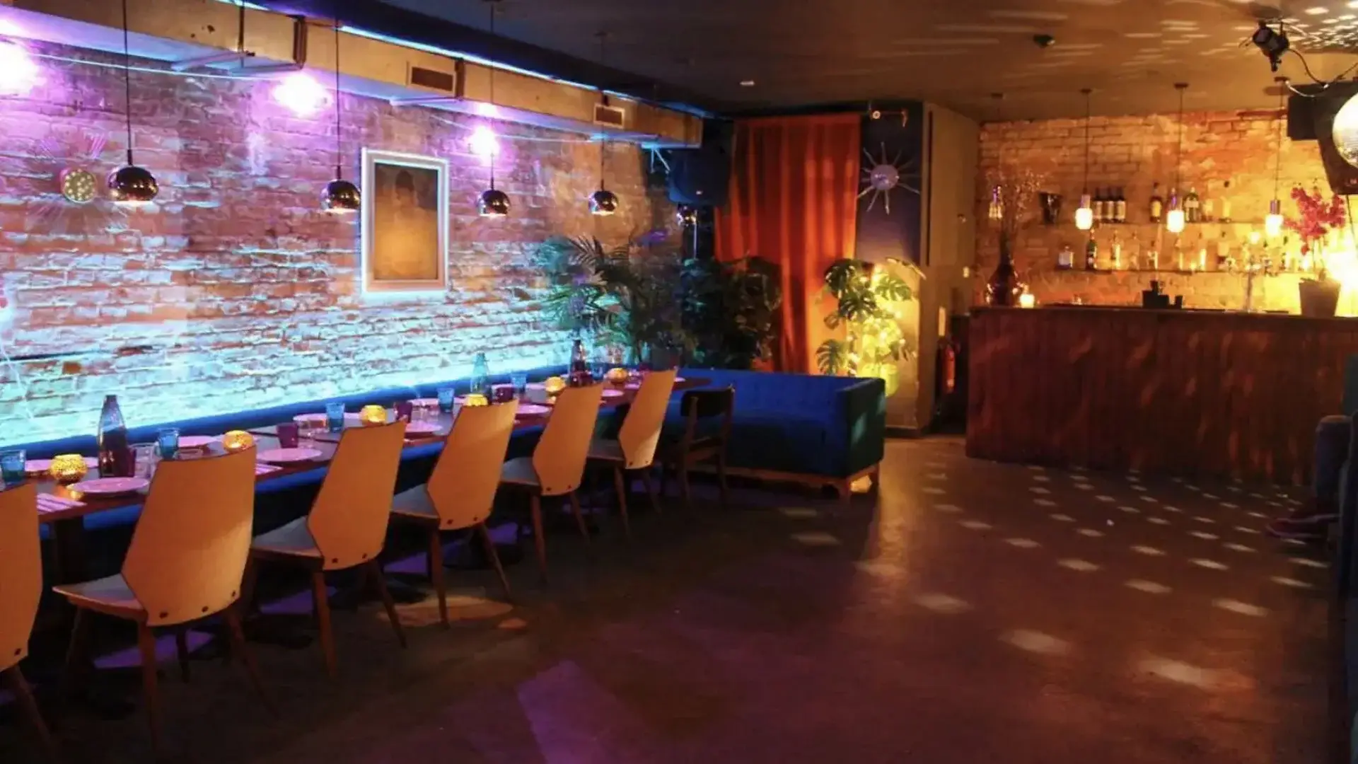 Yellow Banquette seating around the edge of the room with reflective lighting