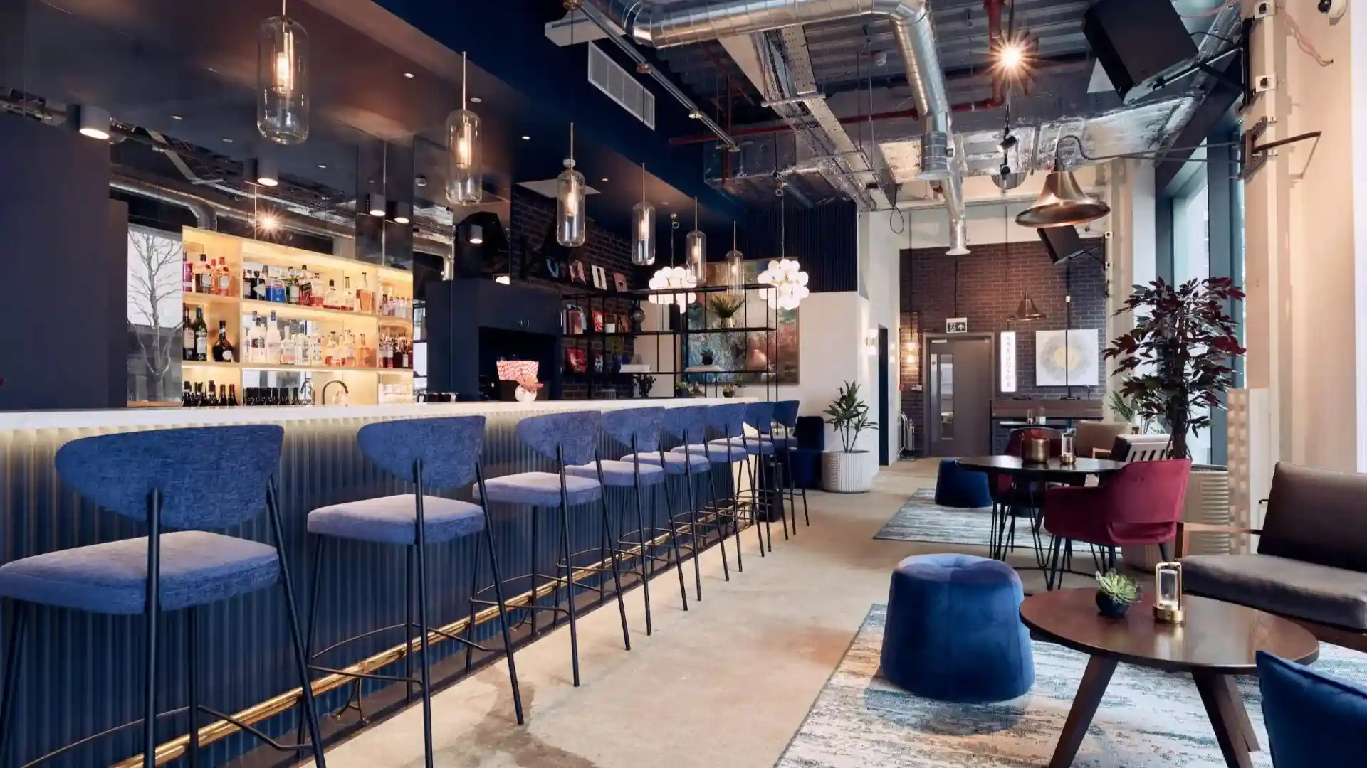 Low stools, next to high stools that line a newly refurbished space with lots of natural light in Canary Wharf